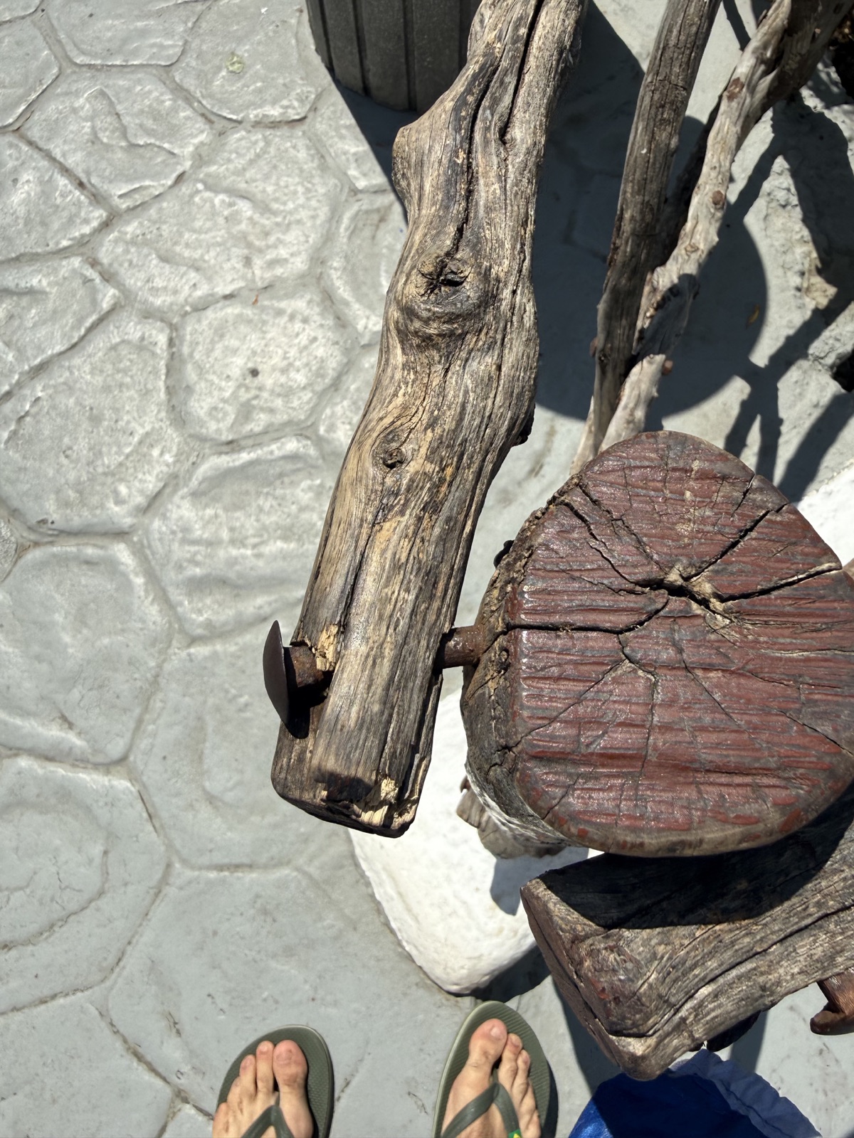 Verwittertes und gerissenes Holz mit einem Metallbefestigungsteil, das aus der Holzbarriere hervorsteht.