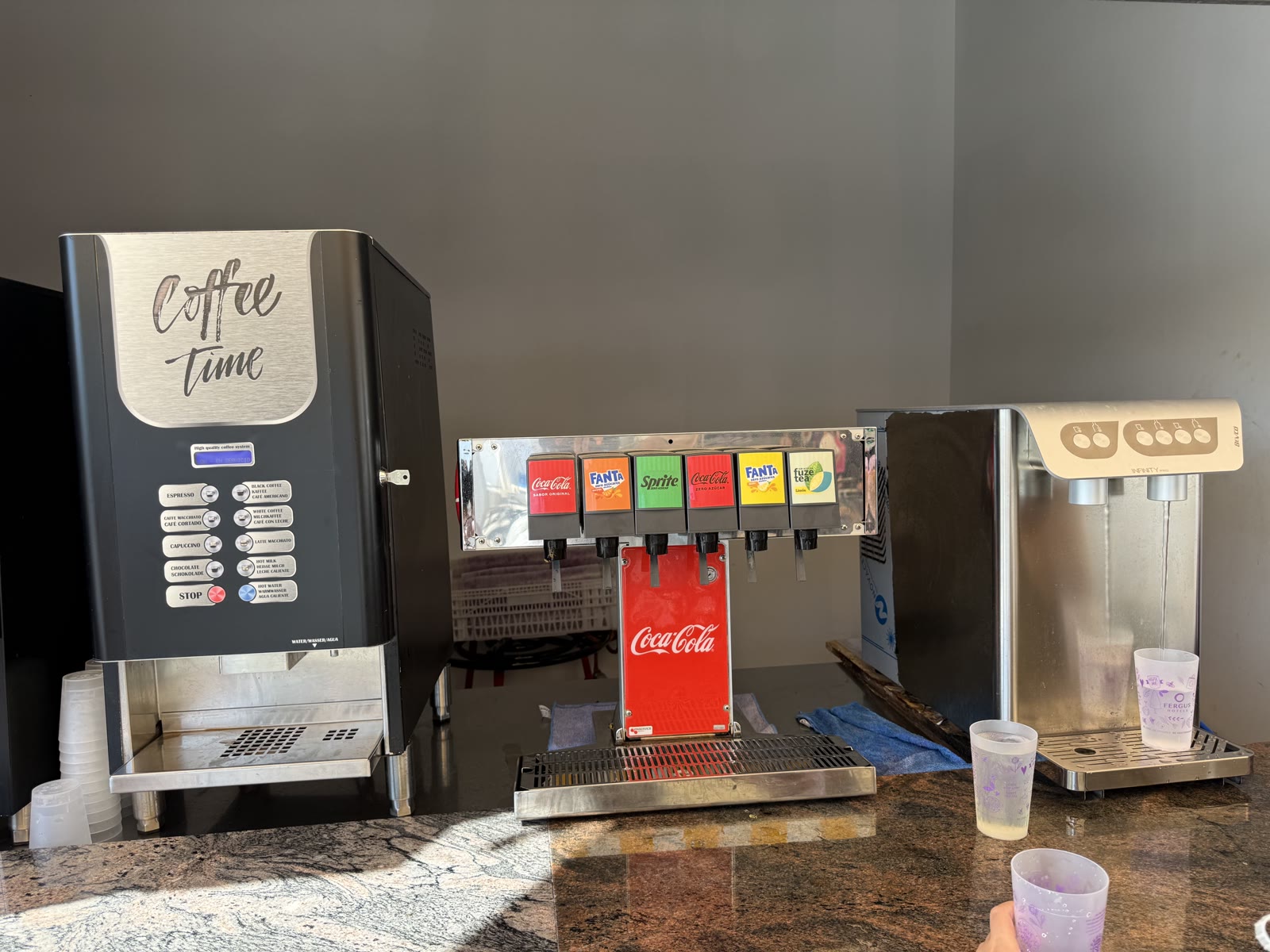 El punt de begudes fora del bufet fotografiat durant l’estada: dispensadors de suc, cafè, refrescos i aigua concentrats en una mateixa zona.