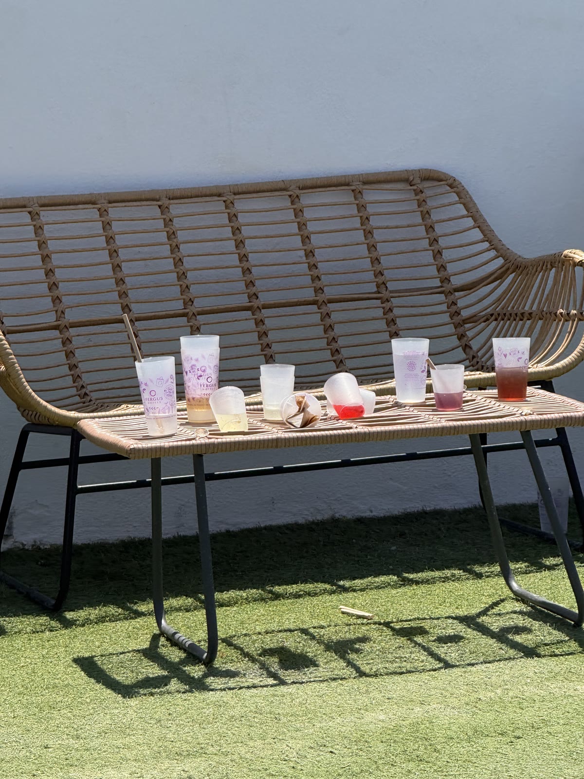 Diversos gots reutilitzables usats, deixats sobre un banc al costat de la piscina.