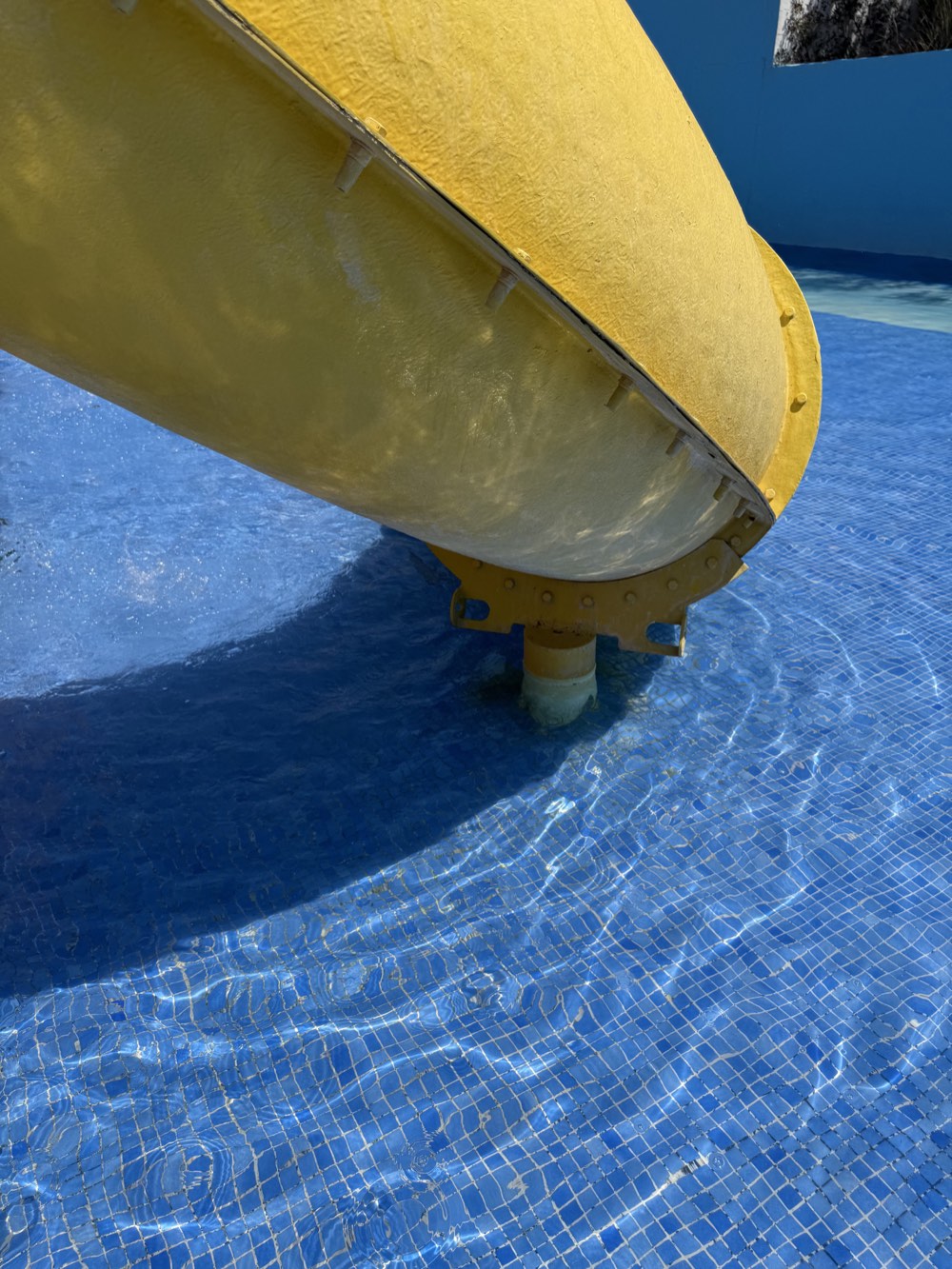 Underside of the yellow slide, including its joint, coating and support.