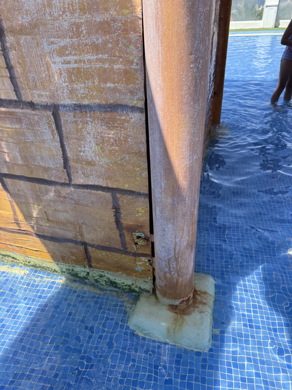 Worn coating, rust-coloured staining and an exposed gap beside the themed structure.