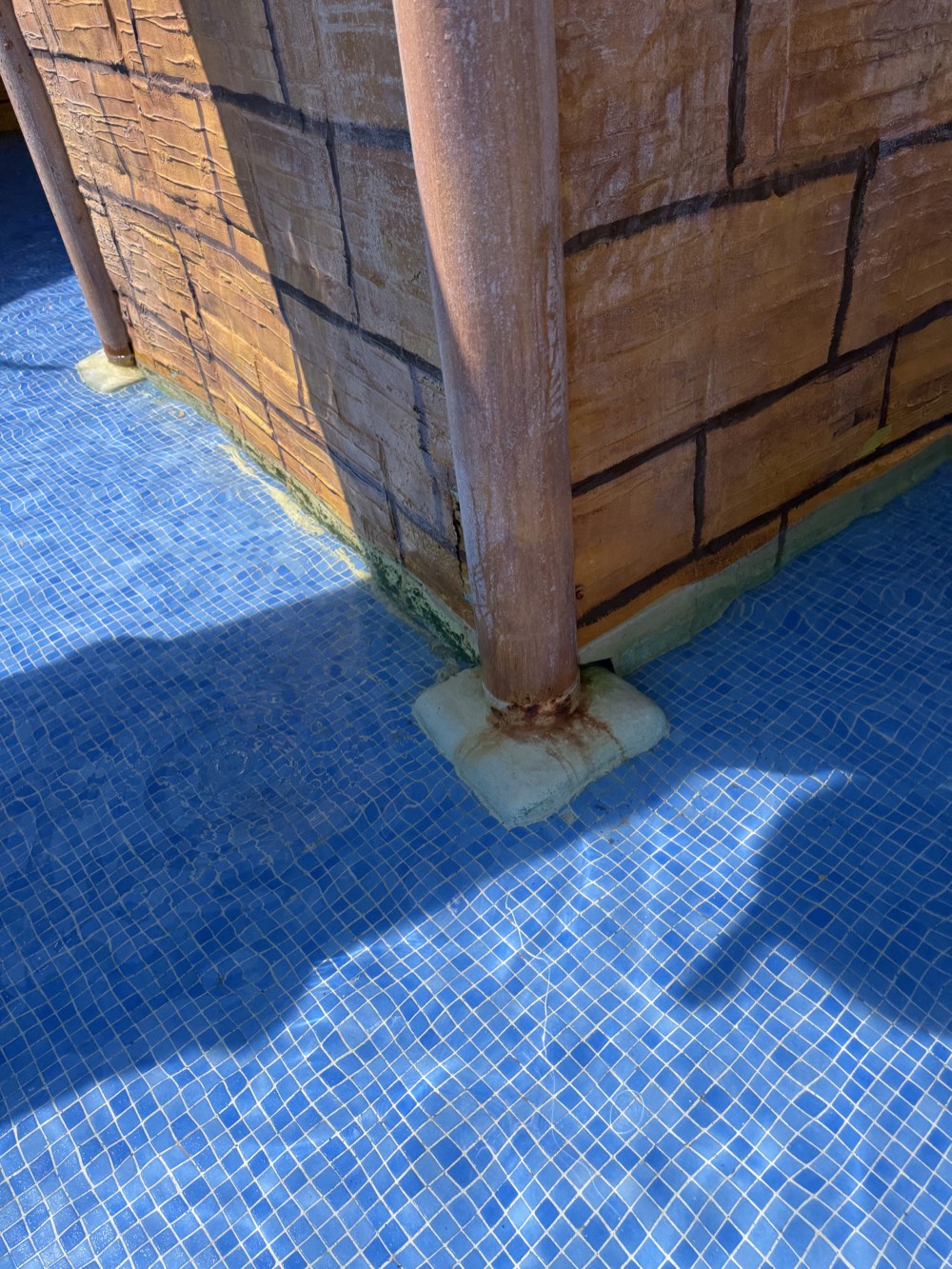 Discoloration and rust-coloured deposits around a support base.