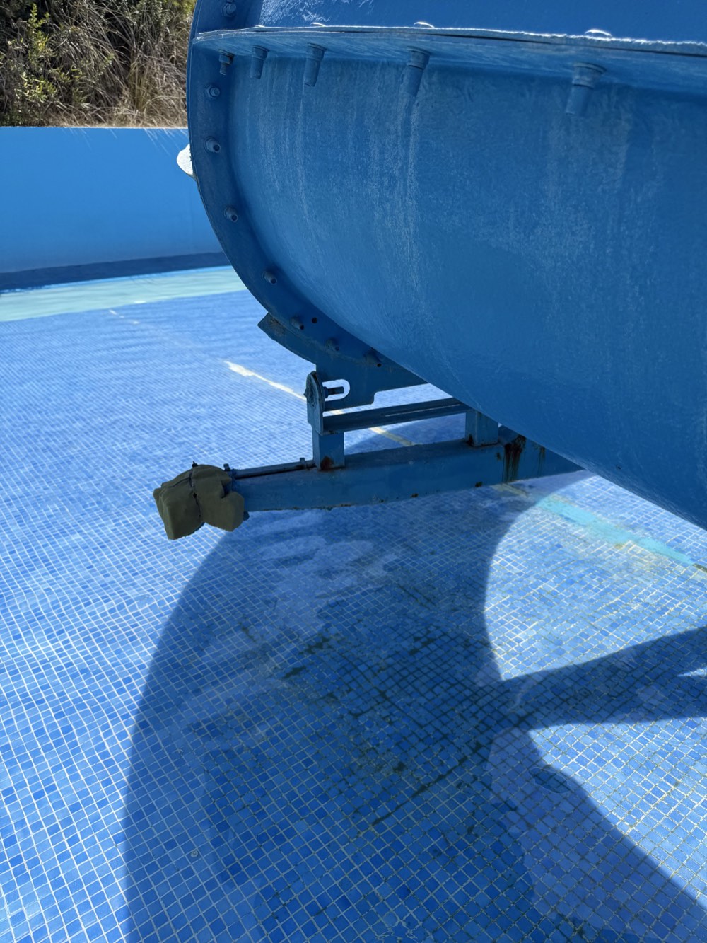 Blue-slide support frame with a protruding bracket end and dark staining.