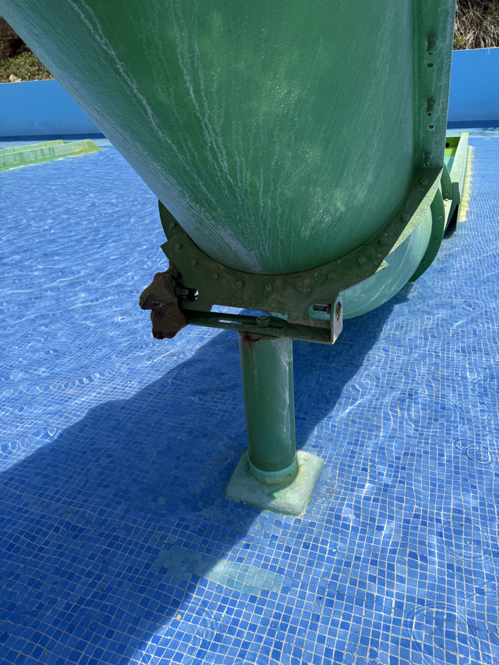 Second angle showing dark material apparently fastened to the green-slide bracket with a plastic cable tie.