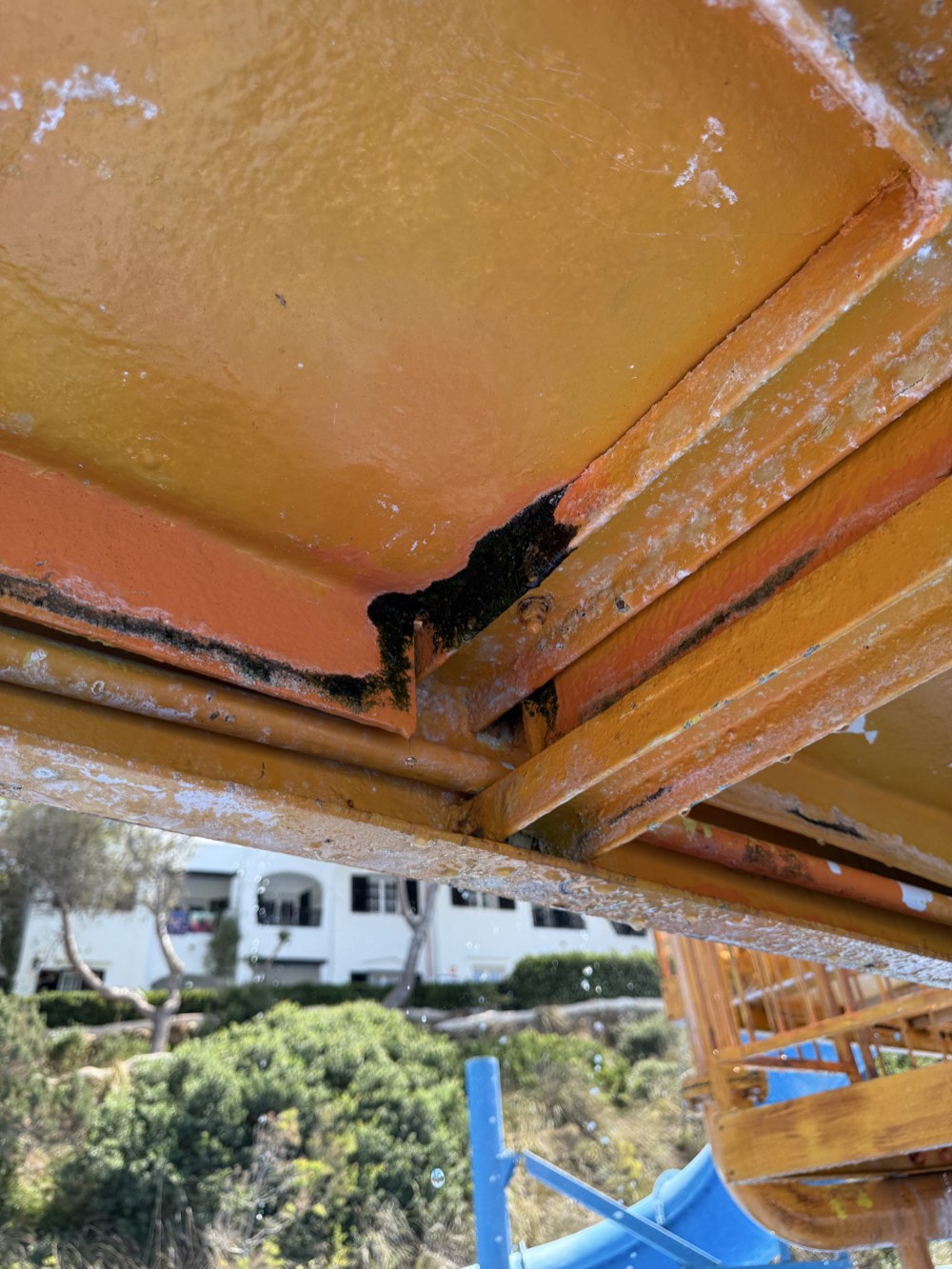 Dark deposits and worn coating visible beneath the orange slide.